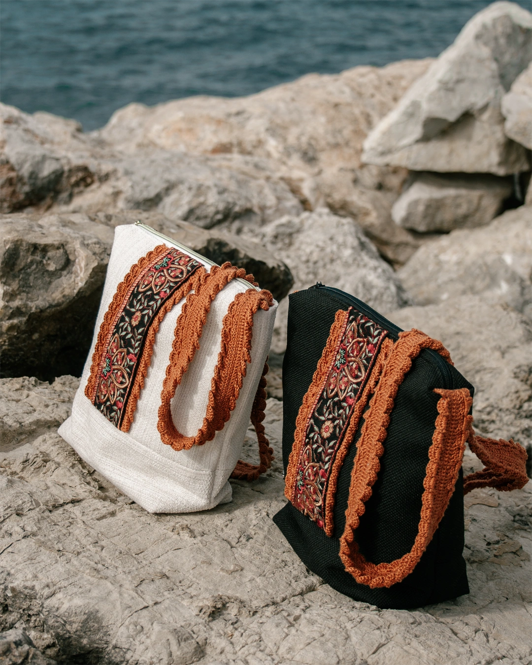 Dos bolsos sobre unas rocas en la costa